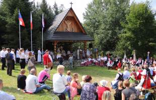 Ołtarz polowy, zebrani na Mszy Świętej, powiewające flagi Polski, Czech i Słowacji