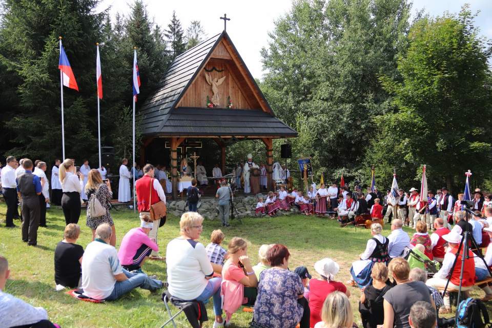 Ołtarz polowy, zebrani na Mszy Świętej, powiewające flagi Polski, Czech i Słowacji