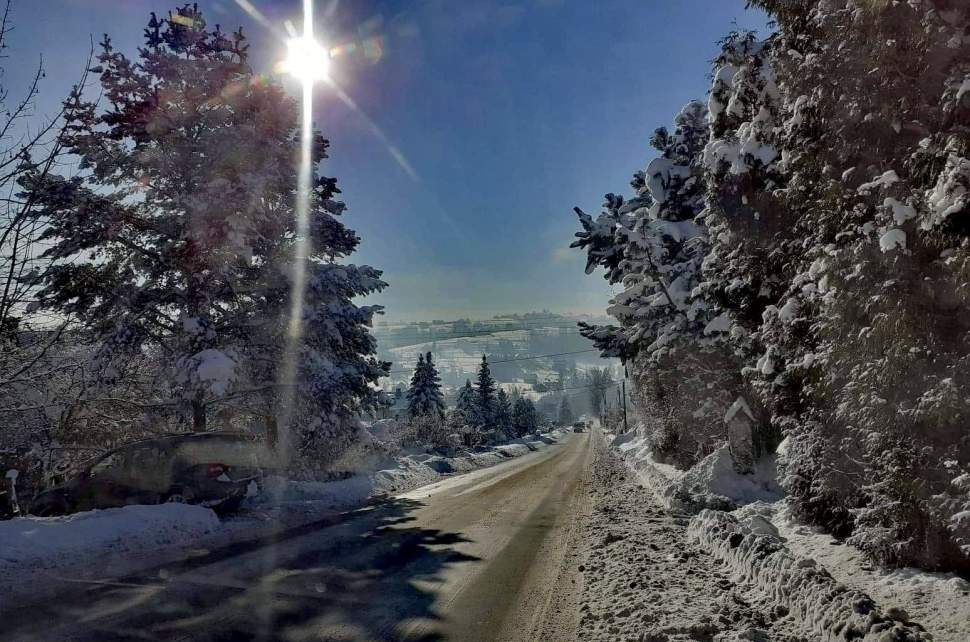 DW 941; widok drogi i chodnika przedstawiający ich zimowe utrzymanie; na zdjęciu widoczne drzewa, błękitne niebo
