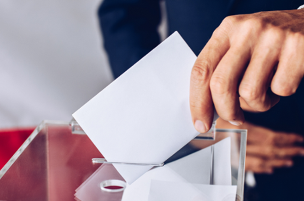 Zdjęcie przedstawia urnę wyborczą.